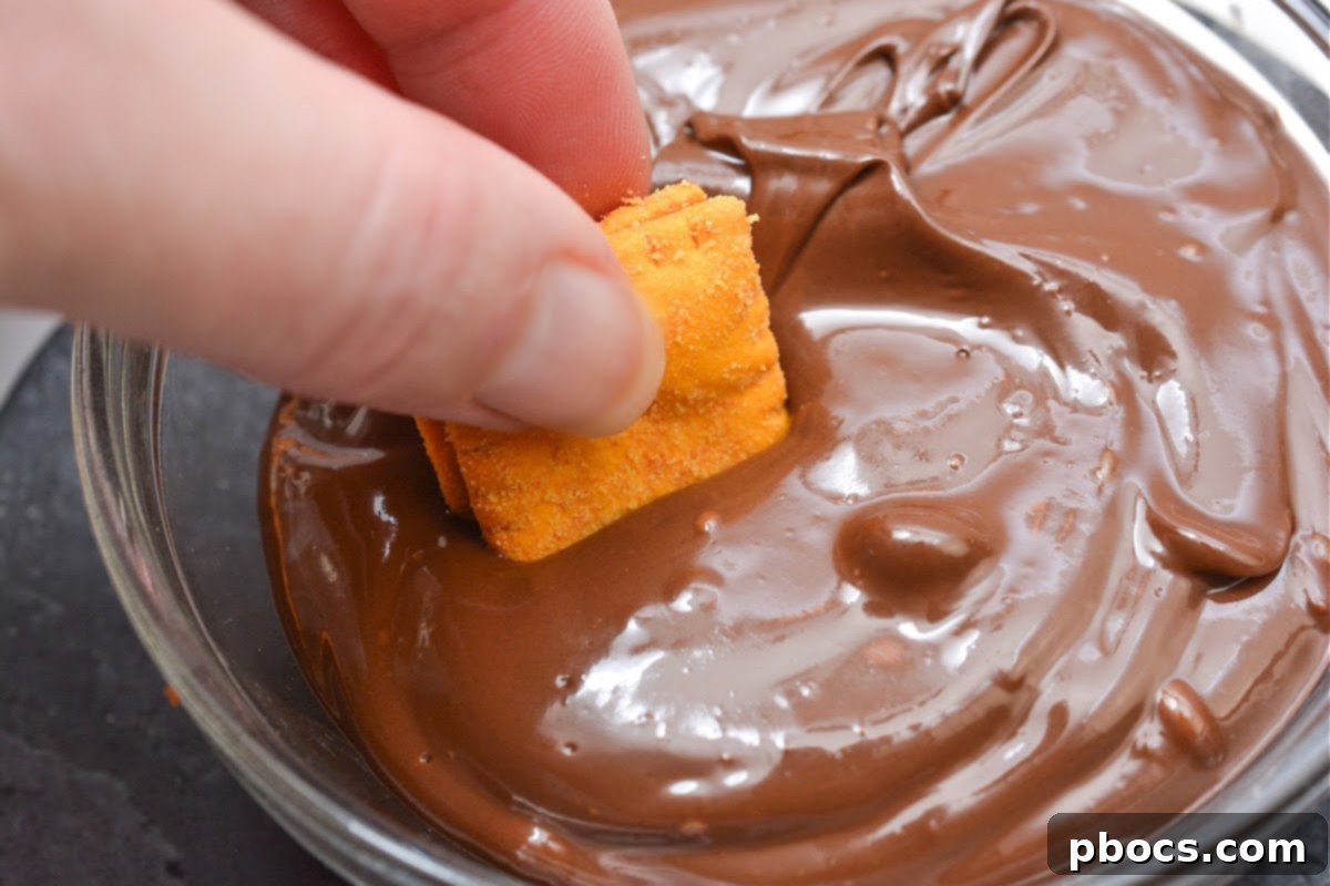Keto Peanut Butter Chocolate Cheese Bites 11 Dipping the cracker into the melted chocolate