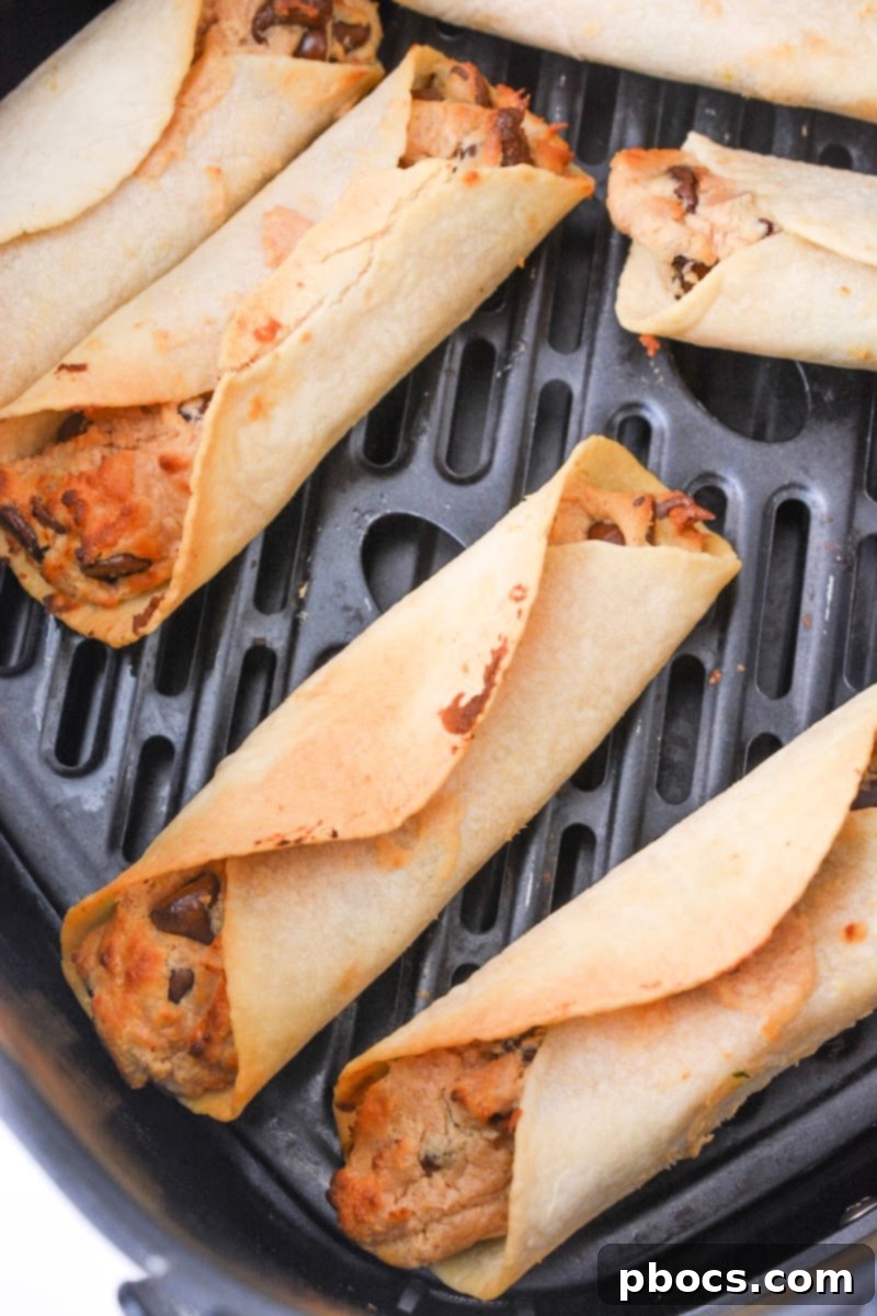 Crispy Low Carb Chocolate Chip Peanut Butter Roll Ups cooking to golden perfection in the air fryer