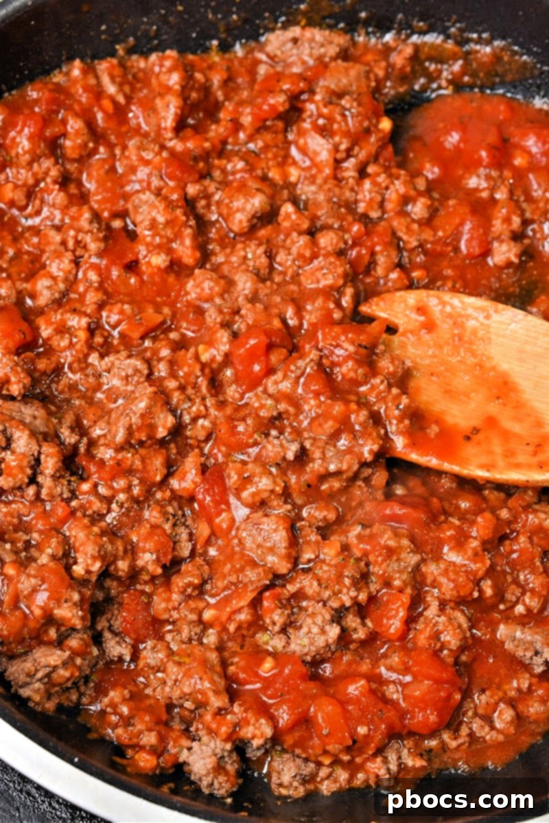 Layering green beans with ground beef and mozzarella