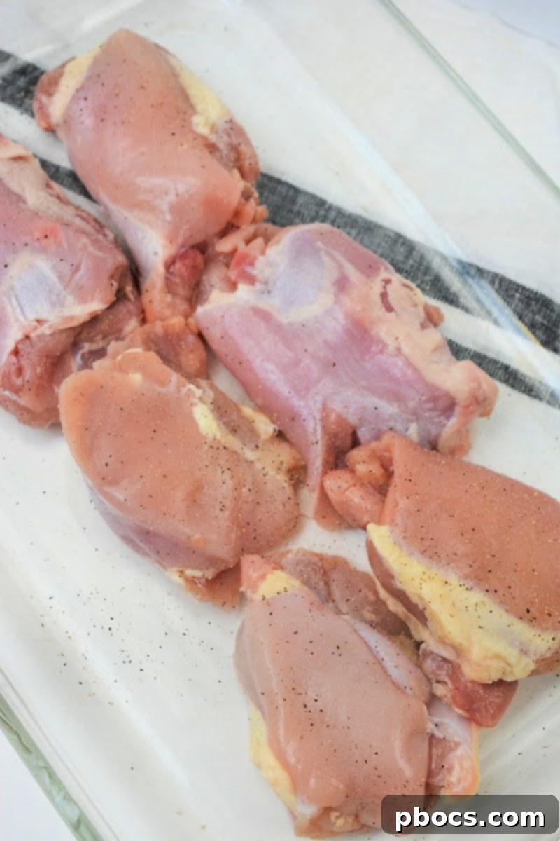 Crispy Baked Cheesy Ranch Keto Chicken Thighs 9 Adding spices to the raw chicken thighs