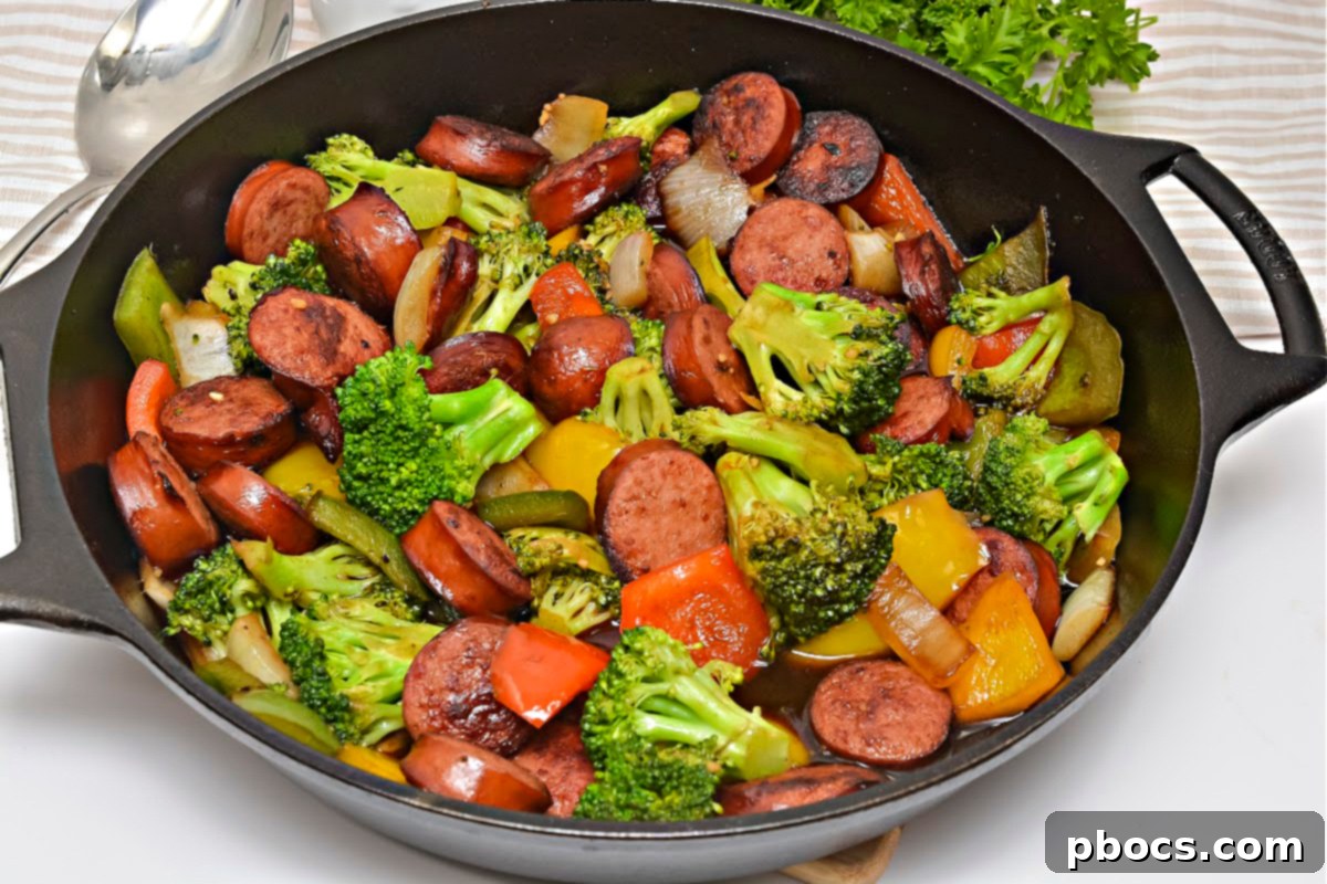 Close-up of Low Carb Asian Sweet and Sour Kielbasa and colorful vegetables simmering in a pan