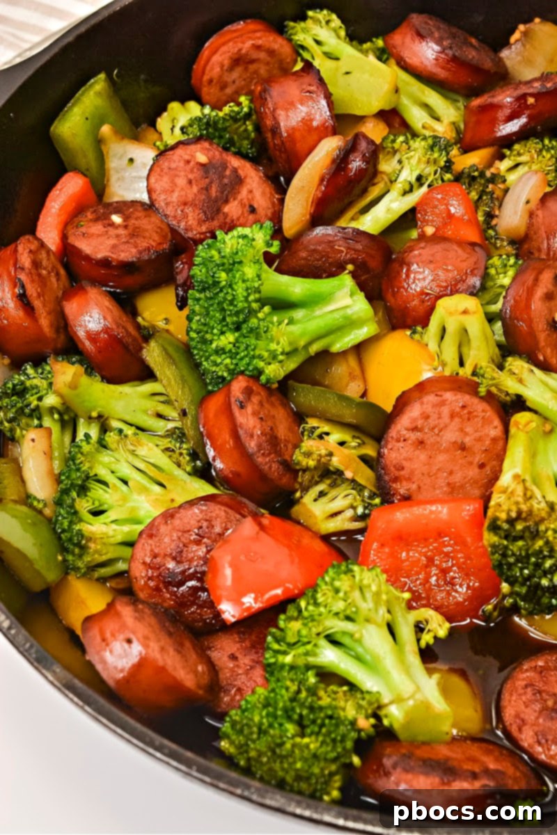 Low Carb Asian Sweet and Sour Kielbasa being mixed in a skillet with the sauce