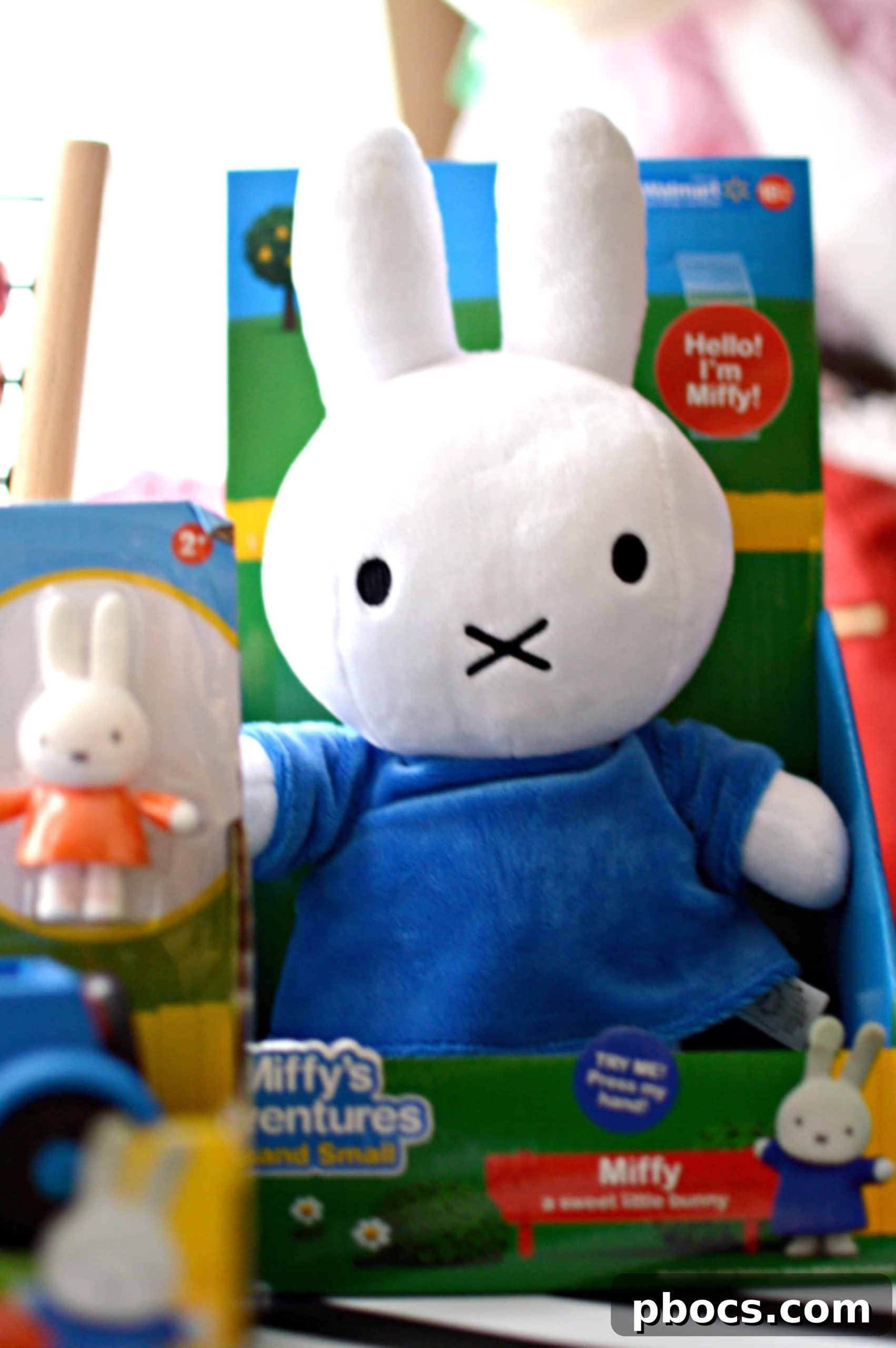 Two children playing with a Miffy plush toy and a Miffy car playset