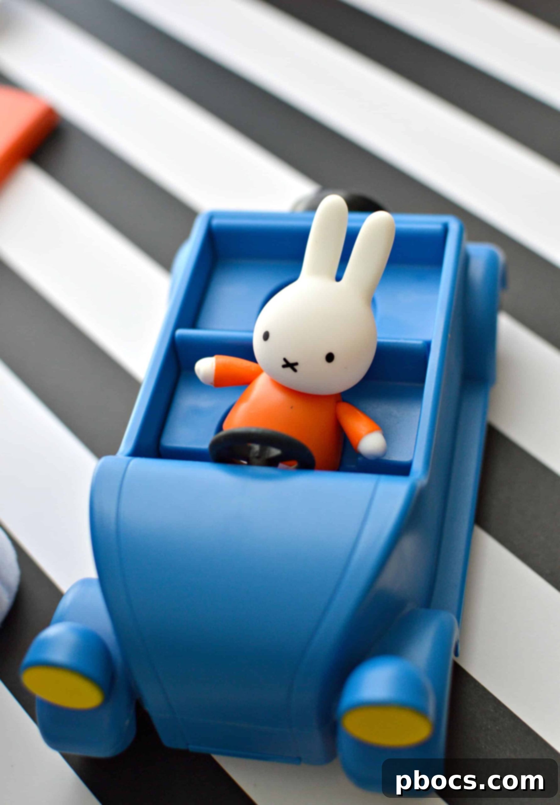 Child happily holding a Miffy plush toy