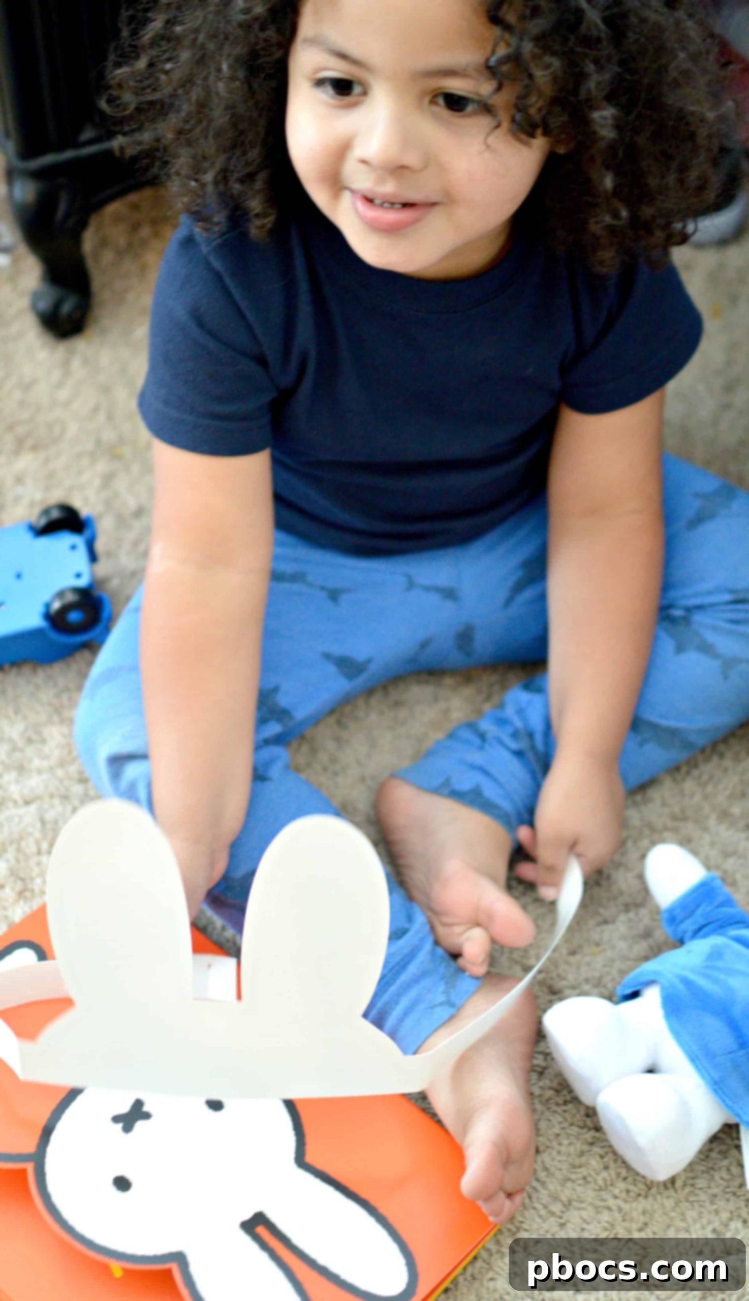 Close-up of a child's hand holding a Miffy plush toy