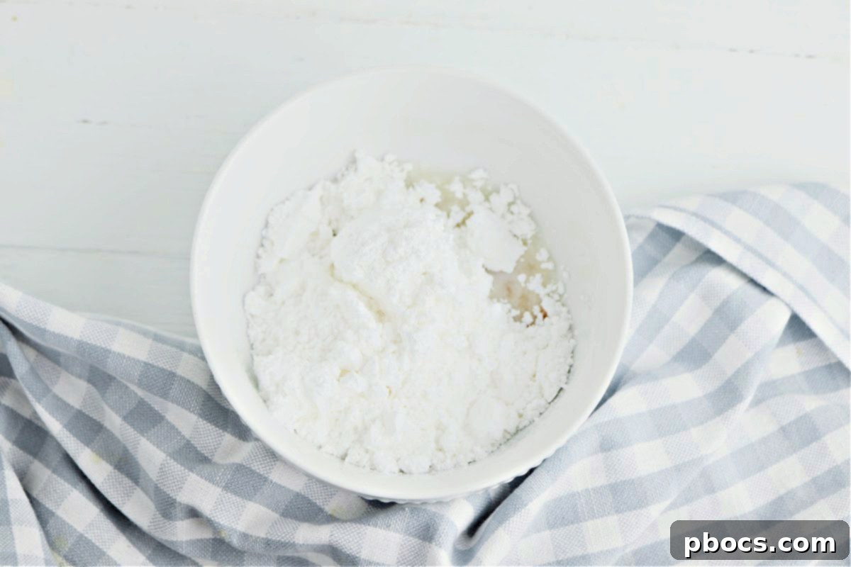 Sprinkling cinnamon sugar topping over the keto pizza crust.