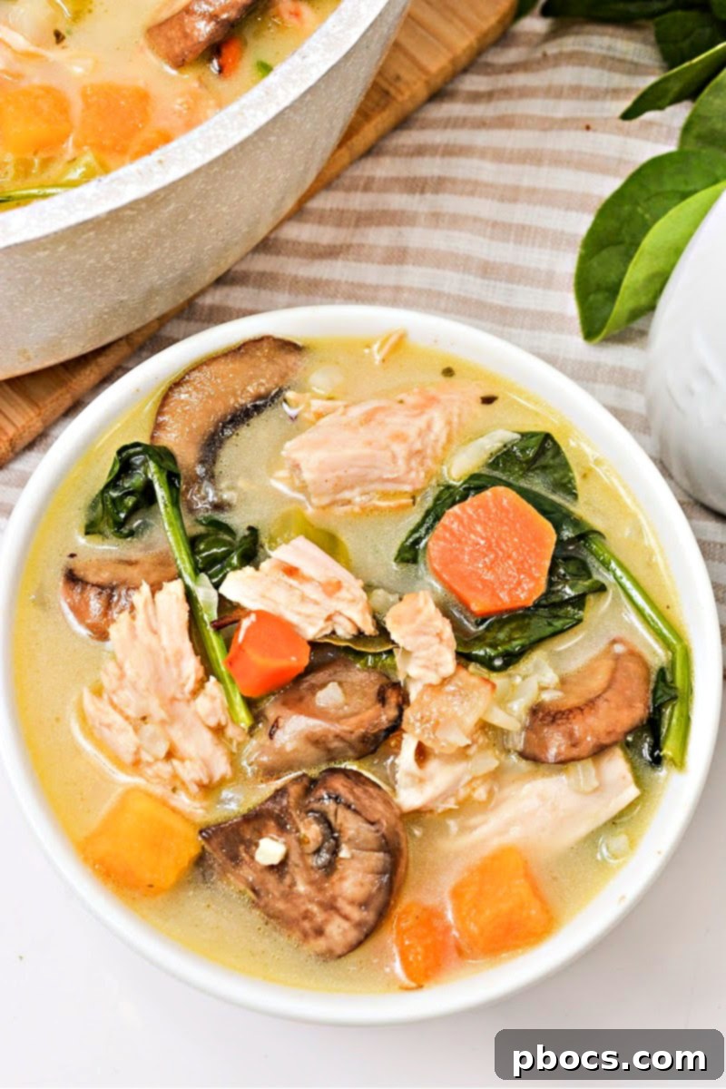 Serving a bowl of creamy Low-Carb Autumn Chicken and Rice Soup