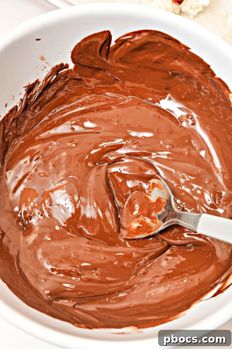 Keto Coco-Almond Bliss Bites 11 Step-by-step: Melting keto chocolate chips with coconut oil to create a smooth coating