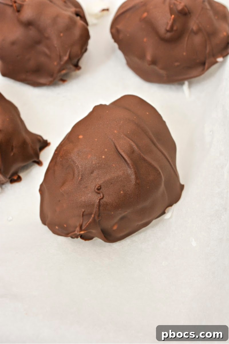 Keto Coco-Almond Bliss Bites 12 Step-by-step: Dipping the frozen coconut clusters into the melted keto chocolate