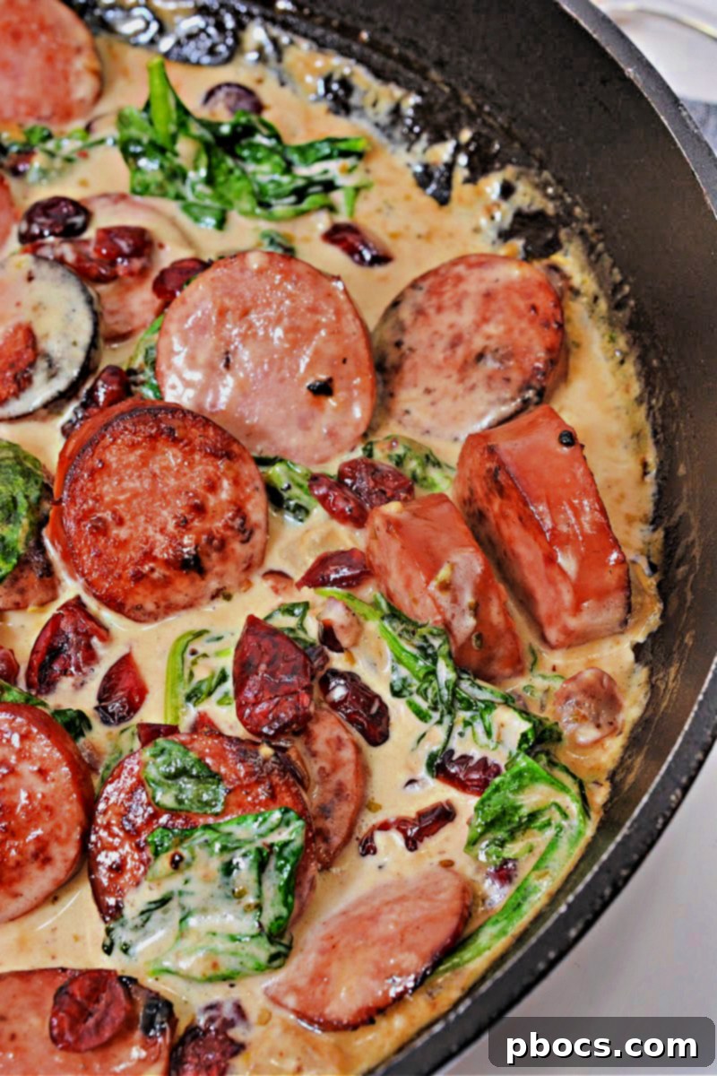 Delicious Low Carb Cheesy White Cheddar Kielbasa Skillet with cranberries and spinach