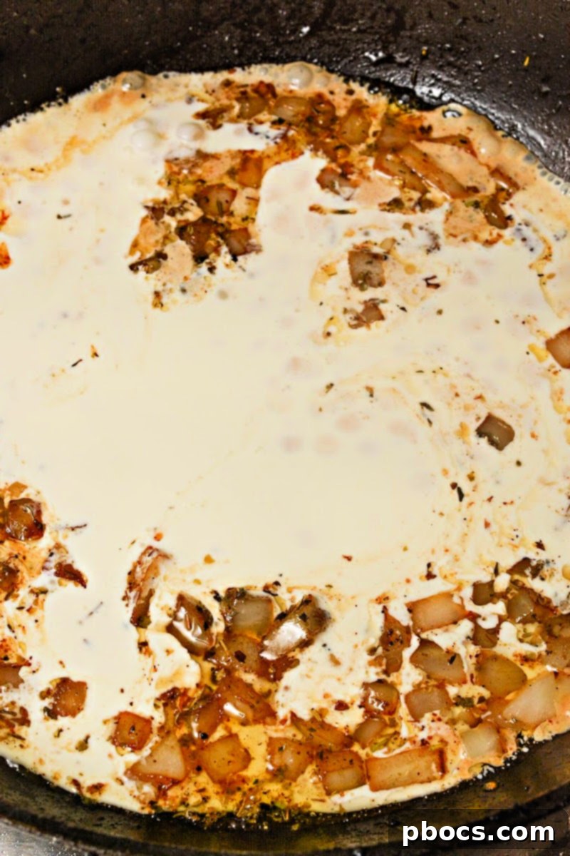 Step 2: Adding heavy cream, garlic, and seasoning to the skillet