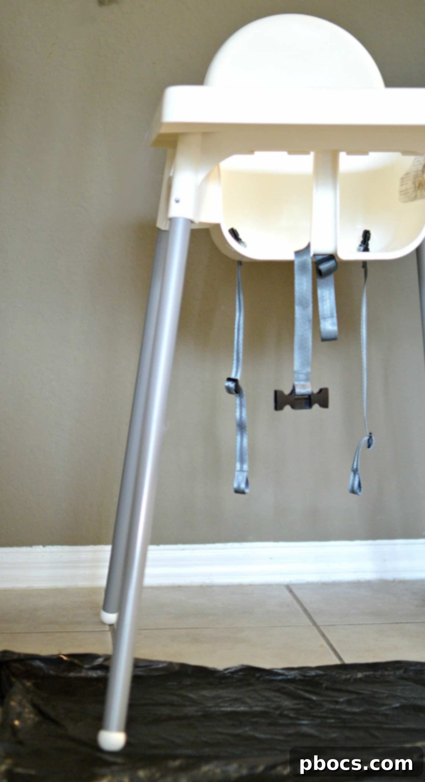 A designated garbage bag placed under a high chair for easy cleanup after toddler meals.
