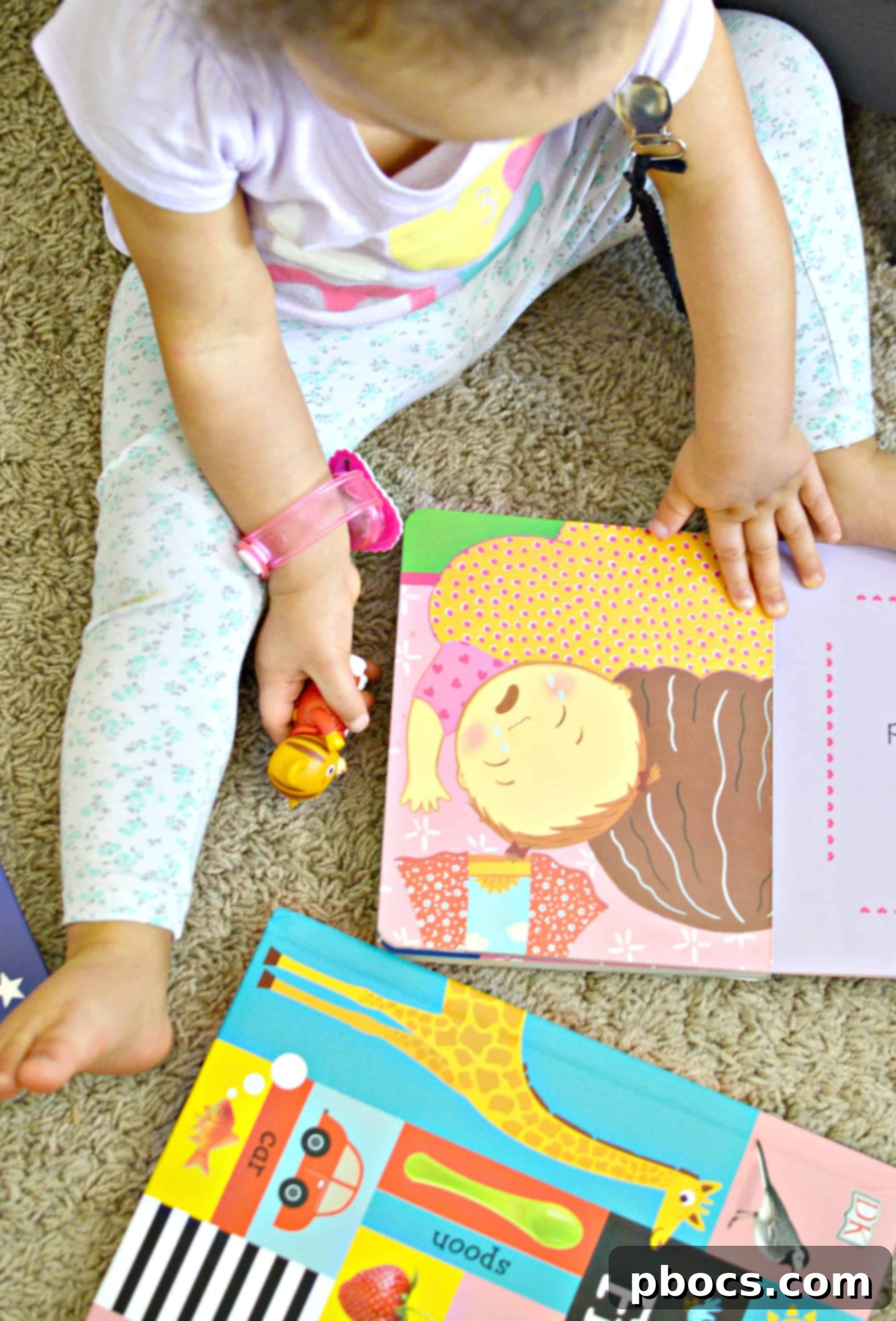 A child's hands holding an open picture book, focusing on the colorful illustrations.
