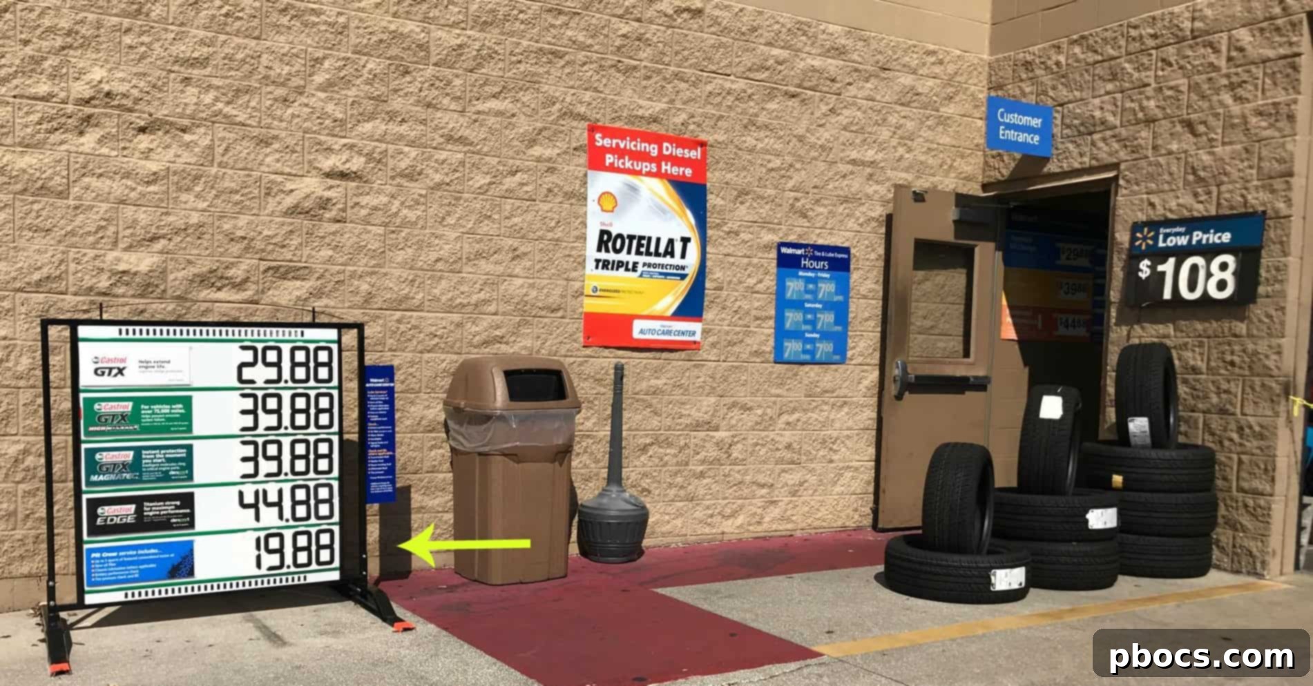 A mechanic at Walmart Auto Center performing a car oil change with Quaker State oil.