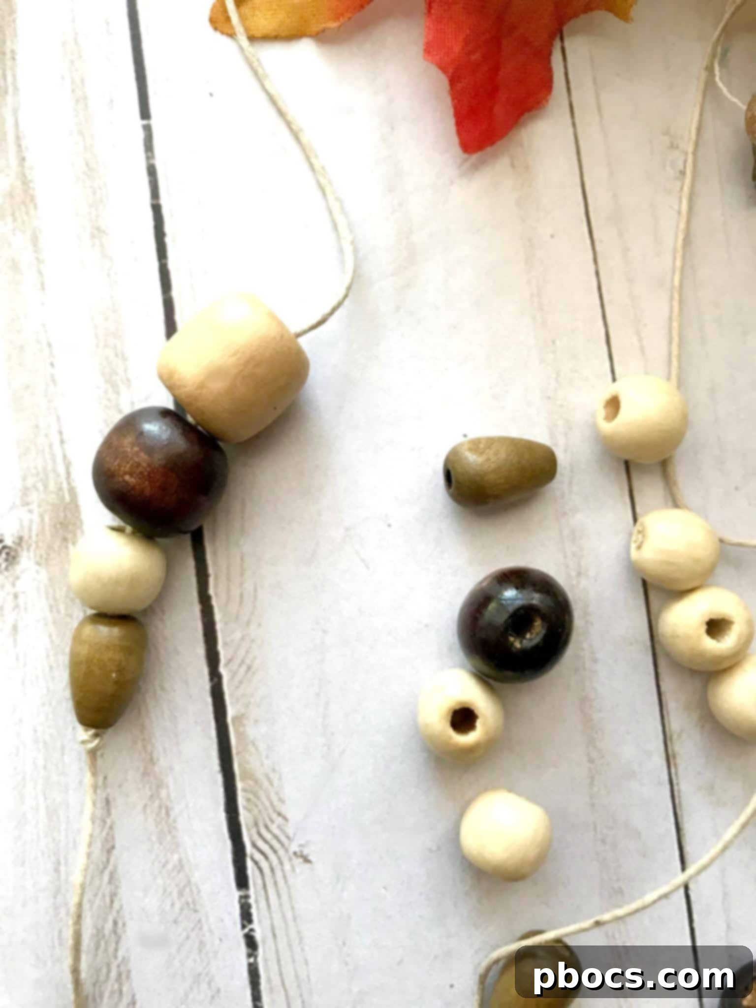 Wooden beads being threaded onto a string, ready to be tied to the keychain.