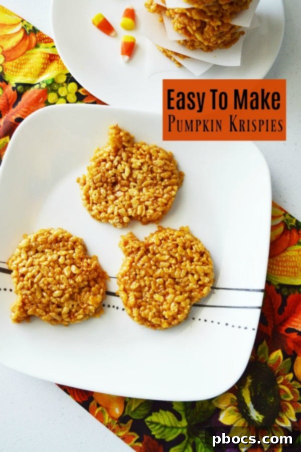 Two hands holding a festive pumpkin-shaped Rice Krispie treat, perfect for Halloween.