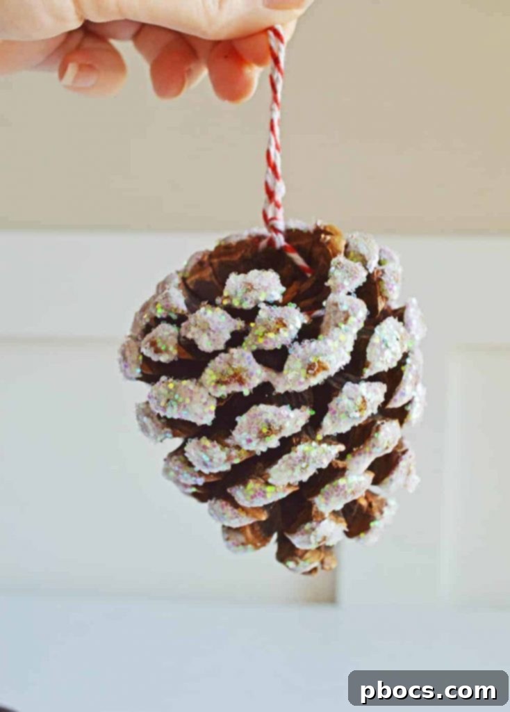 Beautifully crafted glitter pine cone ornaments displayed in a glass bowl, perfect for holiday decoration.