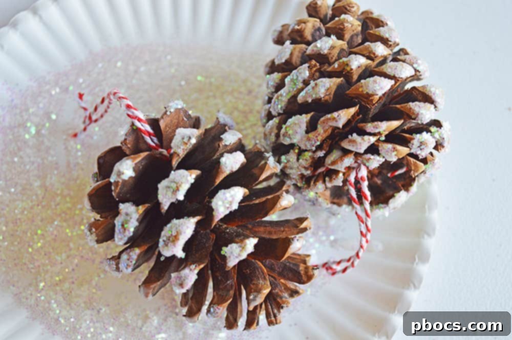 A glue-covered pine cone being rolled in iridescent glitter for a sparkling finish.