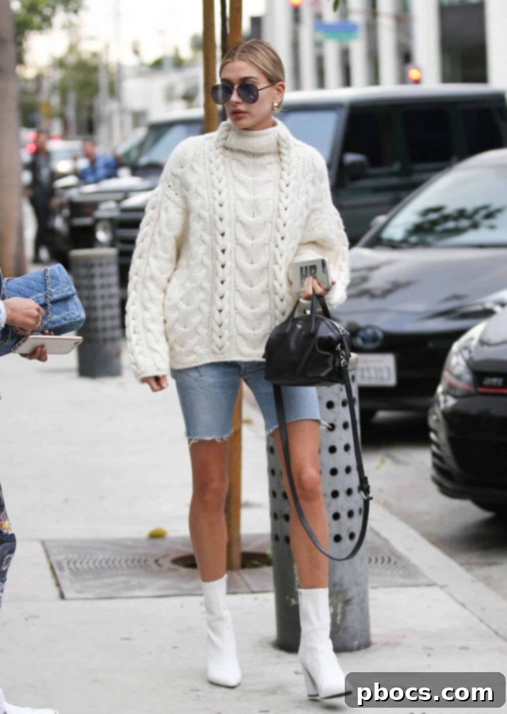Dress Like Hailey Baldwin on a Budget 2 Hailey Baldwin's original outfit featuring an oversized sweater, denim shorts, and white boots.