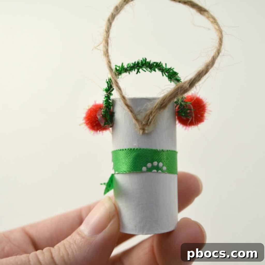 Completing Snowman Earmuffs with Pipe Cleaner Attaching sparkly pipe cleaner for earmuff band on snowman