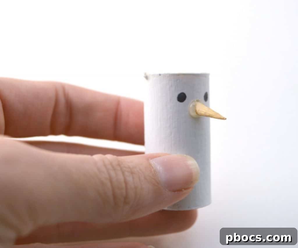 DIY Wine Cork Snowman Ornament: Adding Eyes Drawing eyes on white painted wine cork with Sharpie