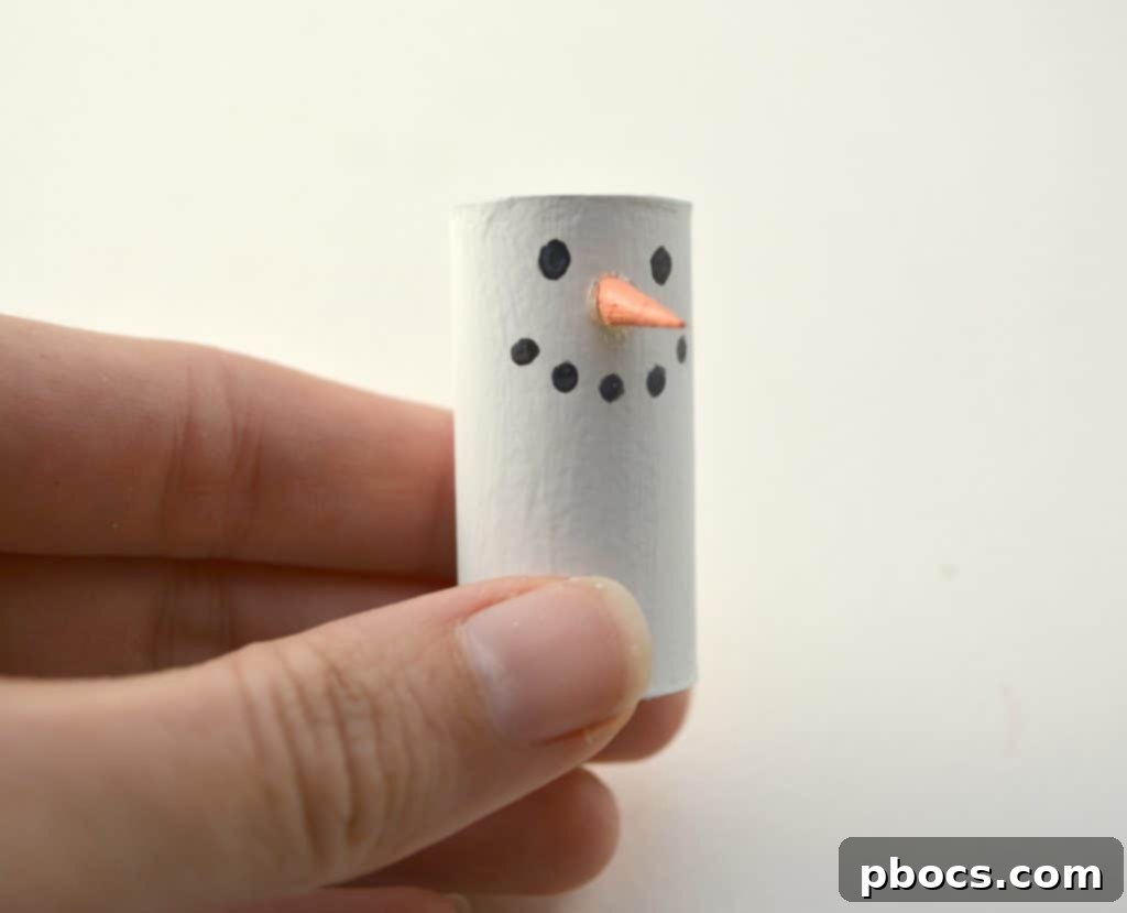 Attaching Snowman's Wooden Carrot Nose Hot gluing wooden nose onto wine cork snowman