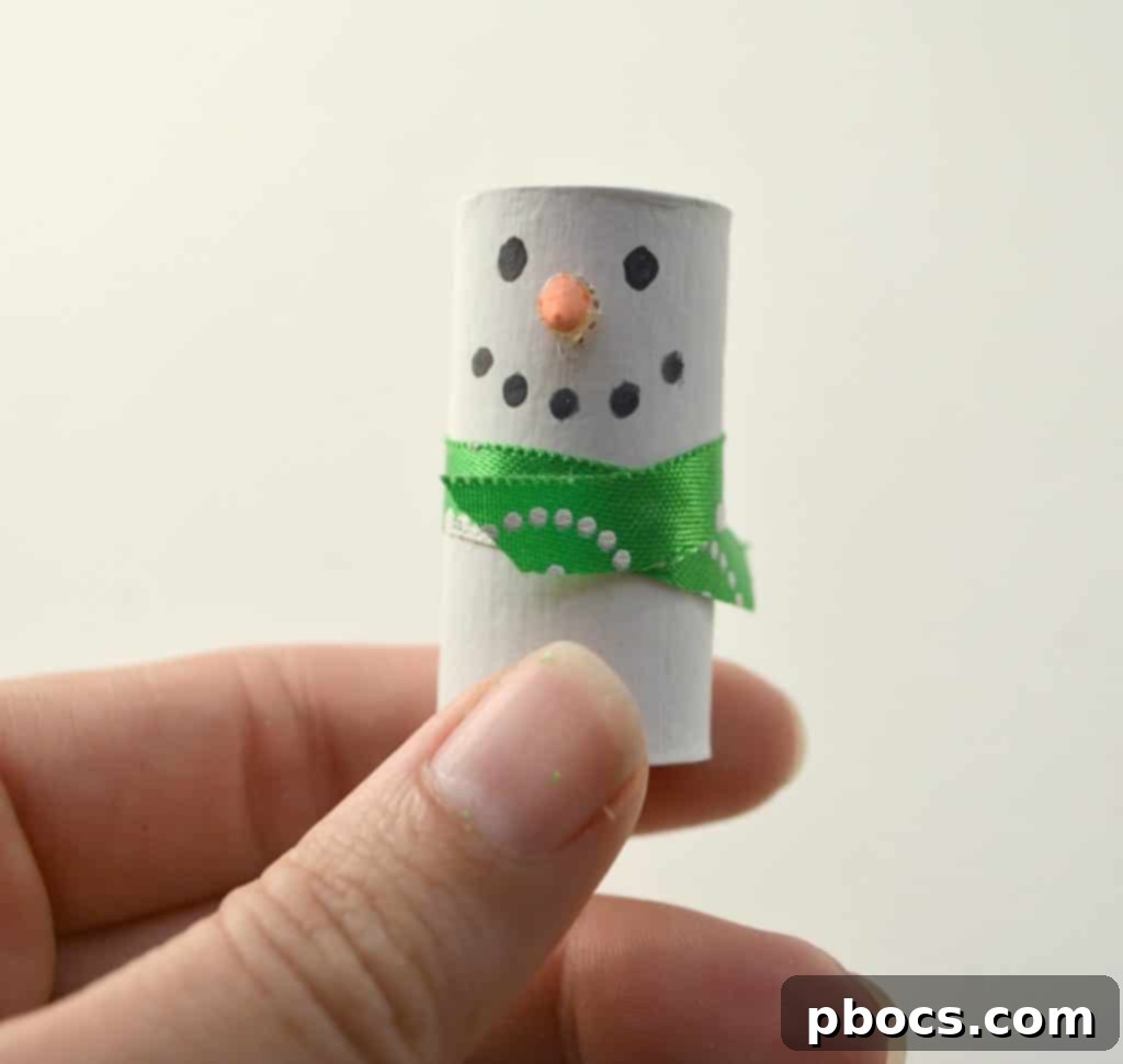 Detailing Snowman Face: Orange Nose and Coal Mouth Painting orange nose and drawing coal mouth on snowman