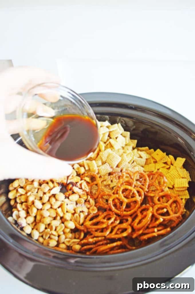 Irresistible Slow Cooker Chex Mix 7 Worcestershire sauce being poured over the Chex Mix ingredients.