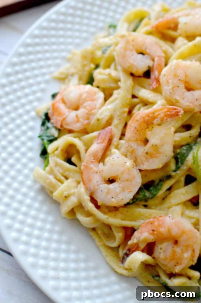 Overhead view of Skinny Cajun Shrimp Fettuccine Alfredo in a serving bowl, highlighting the vibrant colors and rich texture.