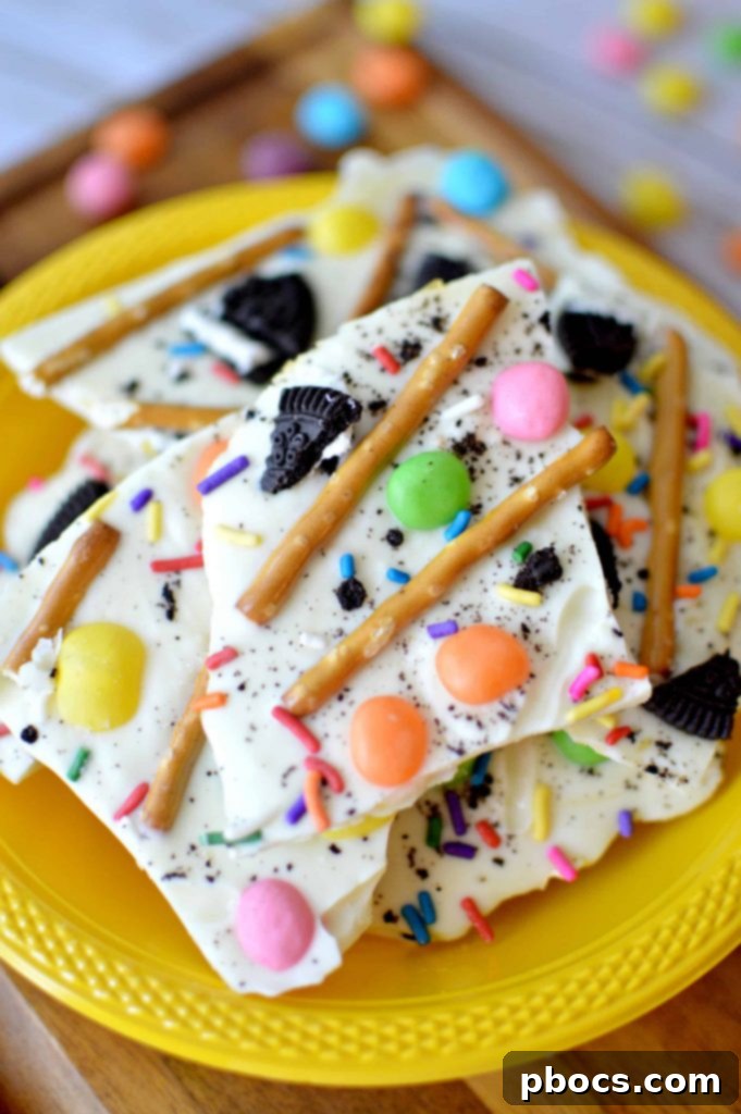Close-up of a piece of white chocolate Easter bark featuring pastel jelly beans, pretzel pieces, and cookie crumbs, showcasing its delightful textures.