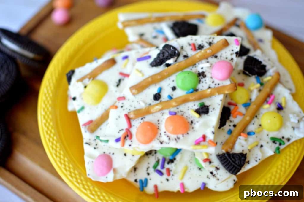 Several colorful pieces of white chocolate Easter bark arranged artfully, highlighting the variety of toppings and the bark's tempting appearance.