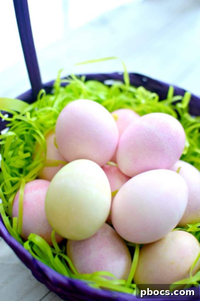 Wiping off excess shaving cream from a dyed Easter egg to reveal the vibrant marbled design.