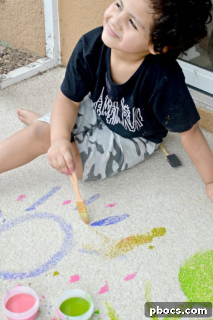 Close-up of child's hand making handprints with sidewalk chalk paint