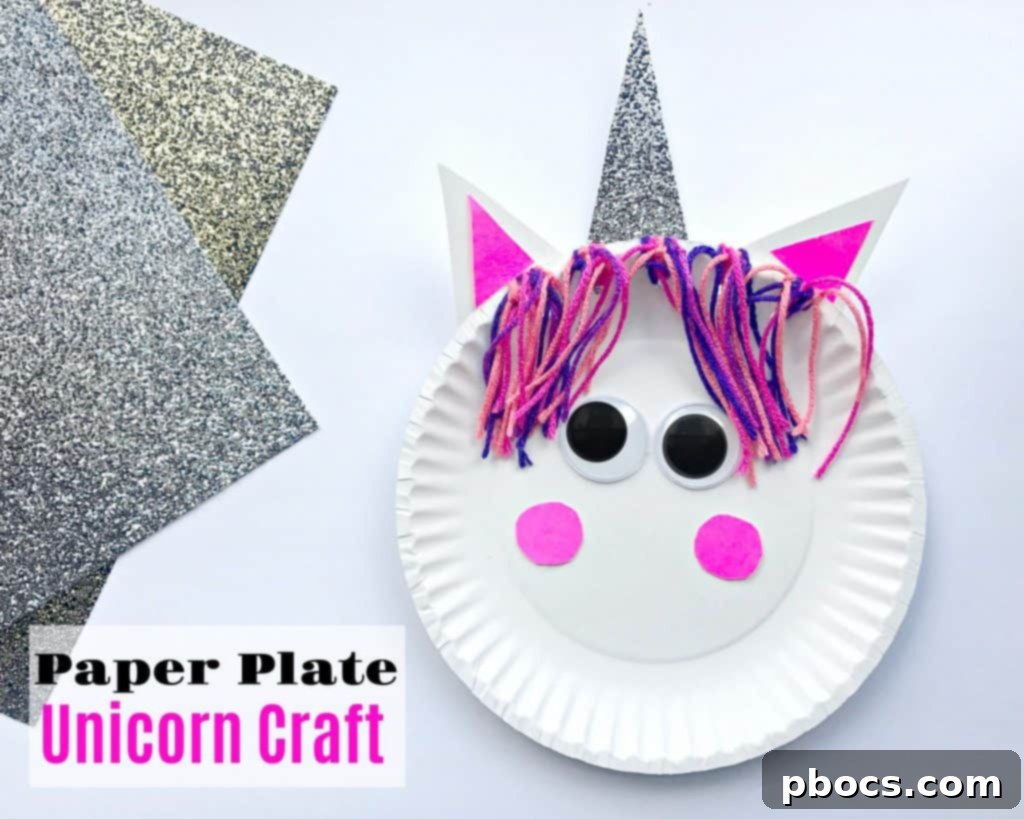 Paper plate unicorn craft with colorful yarn mane and glitter horn