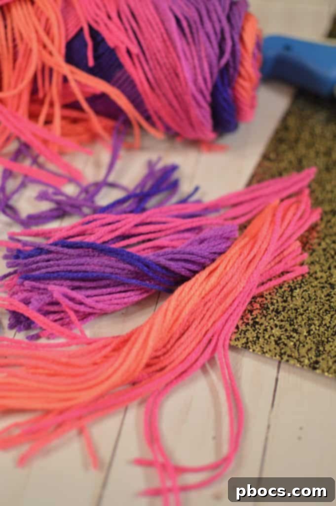 Prepared craft pieces: yarn strips, glitter horn, paper ears, and pink circles