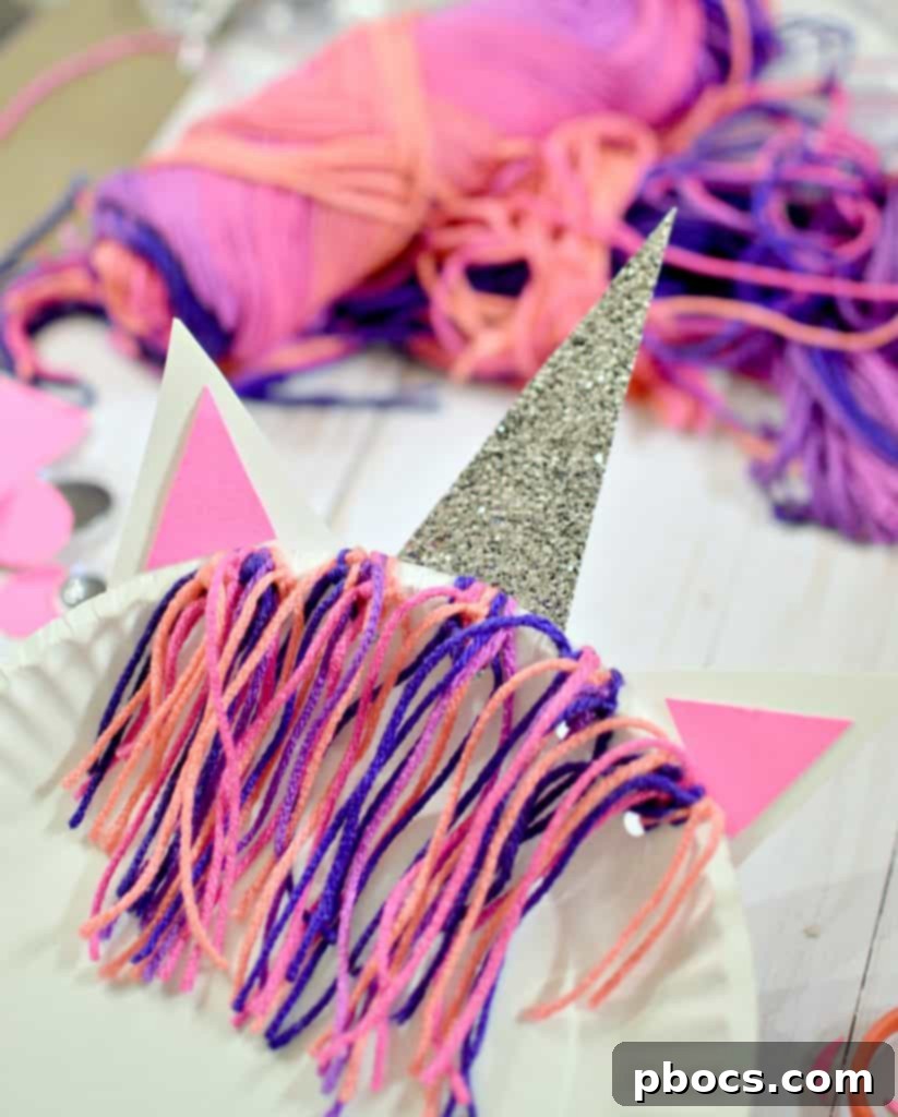 Close-up of yarn being threaded and tied through holes on the paper plate